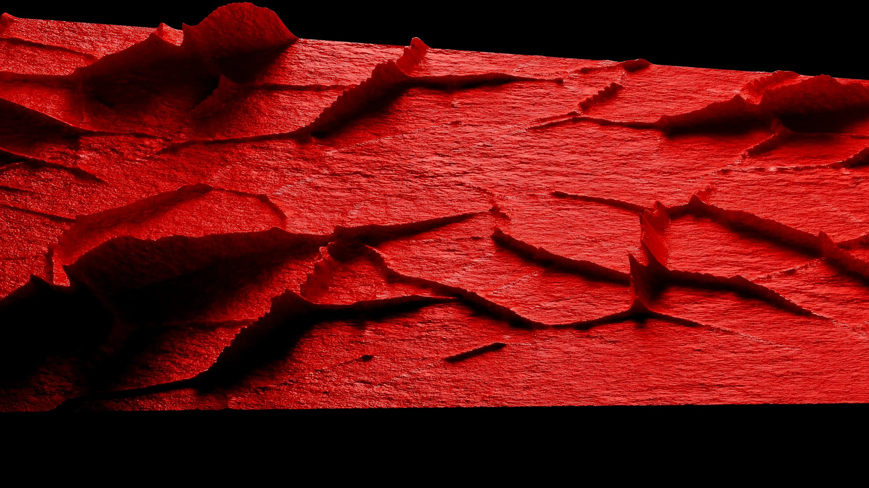Vivid red textured surface with raised seams and layered ridges